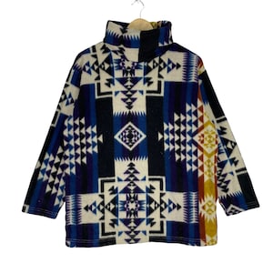 May include: A turtleneck sweater with a colorful geometric pattern in shades of blue, purple, white, orange, and yellow. The pattern resembles a Native American design.