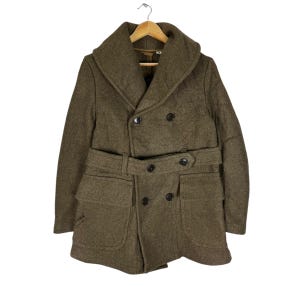 May include: A brown wool double-breasted coat with a large collar, a belt, and two large pockets.