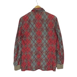 May include: A long-sleeved jacket with a red and grey argyle pattern. The jacket is suspended on a wooden hanger. The cuffs are a solid tan colour. The background is white.