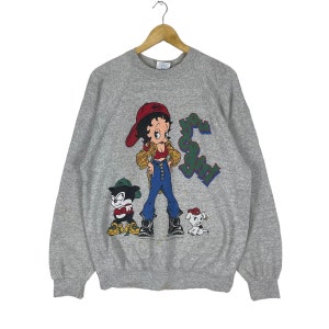 Peut inclure: Sweat-shirt gris avec une image de dessin animé de Betty Boop portant un chapeau rouge et un jean bleu. Le texte "You Go Girl" est imprimé sur le sweat-shirt.