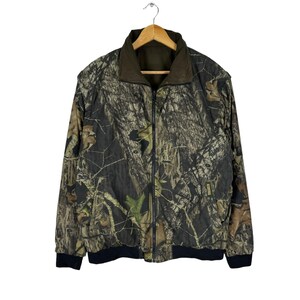 May include: A camouflage-patterned jacket with a zip closure and black trim. The jacket is made of a lightweight fabric and has a quilted lining.