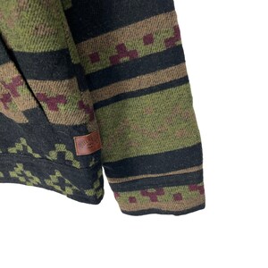May include: A green, black and brown patterned jacket with a brown leather patch that says "BILLABONG" on the left sleeve.