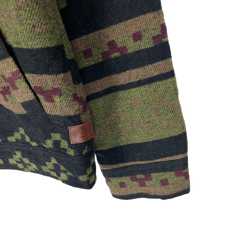 May include: A green, black and brown patterned jacket with a brown leather patch that says "BILLABONG" on the left sleeve.