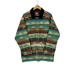 May include: A brown, green, and blue patterned jacket with a black corduroy collar. The jacket has a button closure and two pockets. The label on the jacket reads "Sagmont Japan".