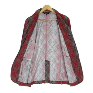 May include: A red, grey, and green plaid jacket with a diamond pattern lining. The jacket is open, revealing the interior lining and pockets. It hangs on a wooden hanger.