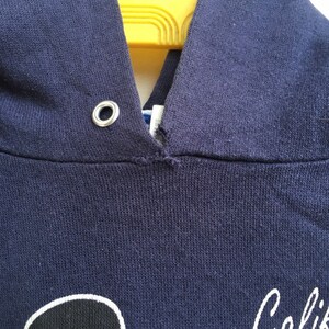 K&ouml;nnte beinhalten: Ein marineblauer Kapuzenpullover mit einer wei&szlig;en Grafik einer Person mit Hut und dem Wort "Golf" in wei&szlig;.