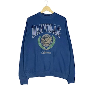 May include: A navy blue sweatshirt with the word "DANVILLE" arched across the top in white lettering. Below the word is a circular emblem with a green wreath and the word "California" at the bottom.