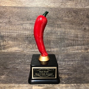 May include: A red chili pepper trophy with a black base and a gold plaque that reads "Hot Stuff Best Chili Award".
