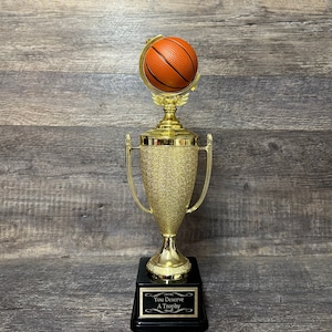 Puede incluir: Un trofeo de baloncesto dorado con una base negra. La base tiene una placa negra con el texto "You Deserve A Trophy".