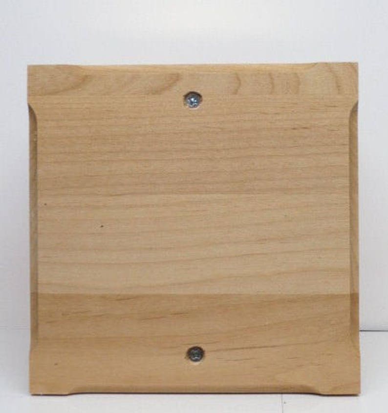 Peut inclure: Une plaque en bois brun clair, simple, avec des bords arrondis et deux vis argent&eacute;es.