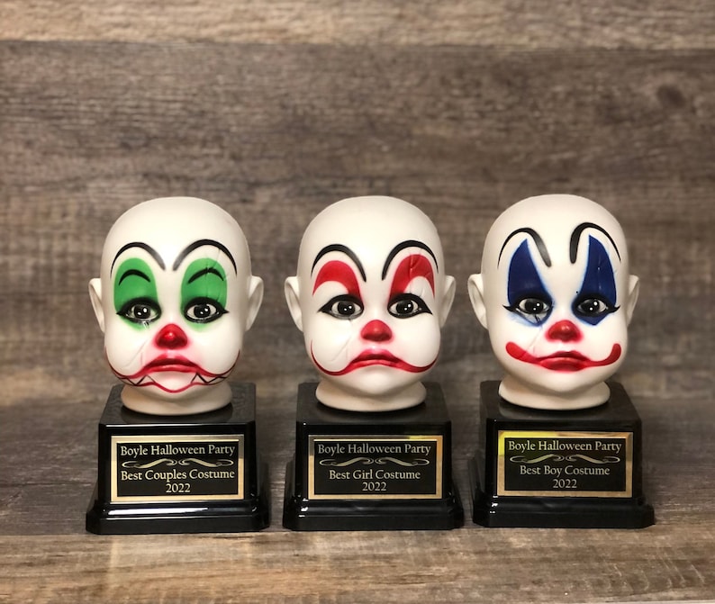 May include: Three white porcelain clown head trophies with black bases and gold lettering. The trophies are labelled "Boyle Halloween Party" with the categories "Best Couples Costume", "Best Girl Costume", and "Best Boy Costume".
