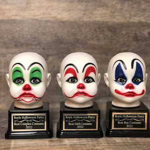 May include: Three clown head trophies with black bases and gold plaques. The plaques read "Boyle Halloween Party" and list the award categories: "Best Couples Costume", "Best Girl Costume", and "Best Boy Costume".