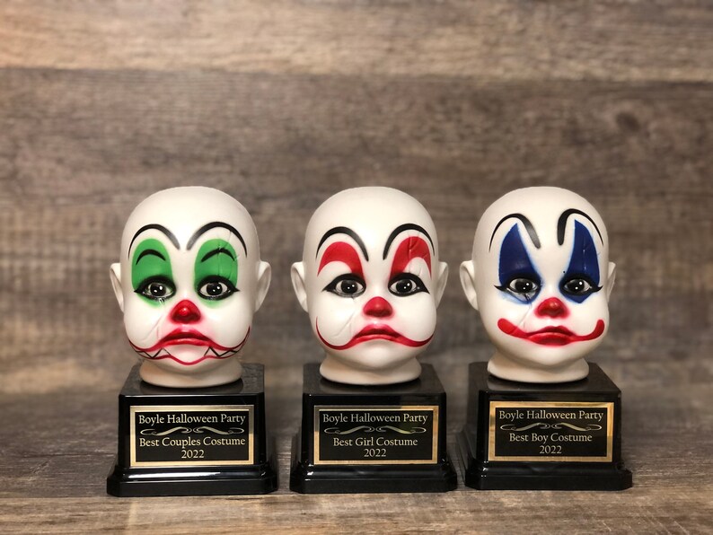 May include: Three clown head trophies with black bases and gold plaques. The plaques read "Boyle Halloween Party" and list the award categories: "Best Couples Costume", "Best Girl Costume", and "Best Boy Costume".