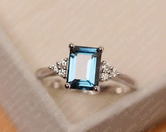 Anillo de compromiso de oro blanco con topacio azul de Londres, talla esmeralda.