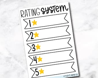 May include: A white sticker with the text "RATING SYSTEM TRACKER" at the top. The sticker has a rating system with five banners, each with a number and a yellow star. The text "BOOK RATING SYSTEM" is at the bottom.
