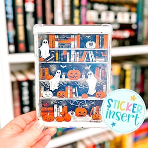 May include: Clear plastic sticker insert featuring a Halloween-themed bookshelf design. The insert showcases orange pumpkins, white ghosts, books, and spiderwebs against a dark blue background. The text "STICKER INSERT" is also visible.