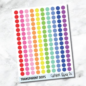 Könnte beinhalten: Ein Bogen mit transparenten Punktaufklebern in Regenbogenfarben. Die Punkte sind in vertikalen Spalten angeordnet und gehen von Rot nach Violett über. Der Text "Transparent Dots" und "Cricket Paper Co." ist unten aufgedruckt.
