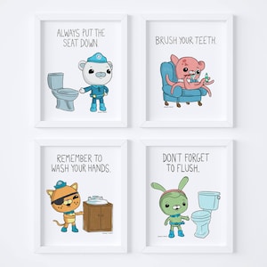 May include: Four white framed prints with cartoon illustrations and text. The top left print shows a polar bear wearing a blue uniform and a blue hat, holding a toilet seat down. The text reads "Always put the seat down". The top right print shows a pink octopus wearing a blue hat, sitting on a blue couch and brushing its teeth. The text reads "Brush your teeth". The bottom left print shows a cat wearing a blue hat and a blue eyepatch, washing its hands. The text reads "Remember to wash your hands". The bottom right print shows a green creature with a blue hat, standing next to a toilet and flushing it. The text reads "Don't forget to flush".