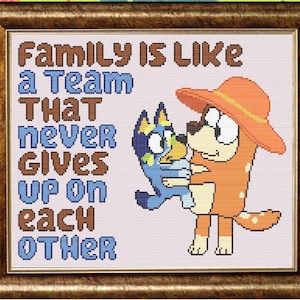 May include: Cross-stitch embroidery with a quote about family being like a team that never gives up on each other. The embroidery features two cartoon dogs, one blue and one orange, hugging.