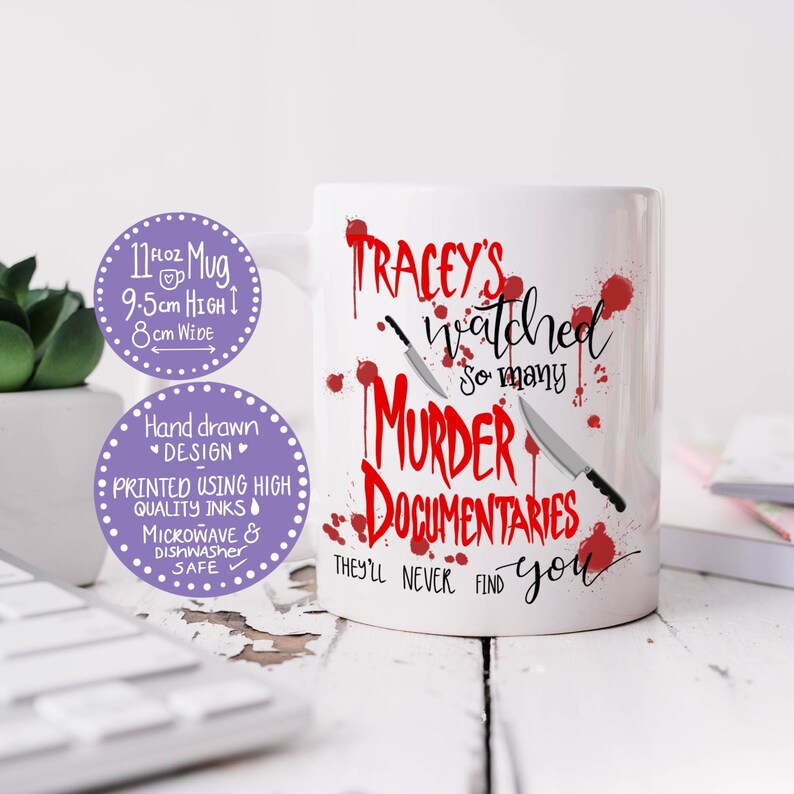 Op de afbeelding: Een witte keramische mok met rode bloedspatten en twee zwarte messen. De tekst op de mok luidt "Tracey's watched so many murder documentaries they'll never find you".