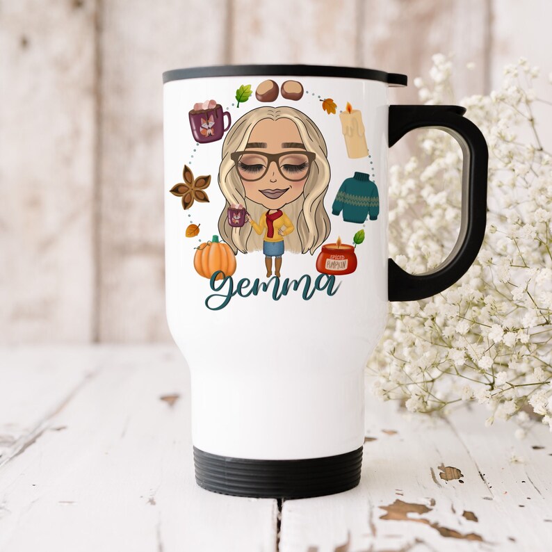 Puede incluir: Taza de viaje blanca con tapa y asa negras. La taza presenta una ilustraci&oacute;n de dibujos animados de una mujer con cabello rubio y gafas, rodeada de iconos de tem&aacute;tica oto&ntilde;al como una calabaza, una vela y un su&eacute;ter. El texto "gemma" est&aacute; escrito debajo de la ilustraci&oacute;n.