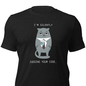 Könnte beinhalten: Dunkelgraues T-Shirt mit einer Cartoon-Katze im Anzug und Kaffeetasse. Der Text über der Katze lautet "I'M SILENTLY" und darunter "JUDGING YOUR CODE."