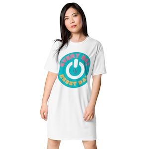 May include: White t-shirt dress with a teal and pink graphic. The graphic features a power button design with the words "EVERY DAY is RESET DAY". The dress is a casual, comfortable style.