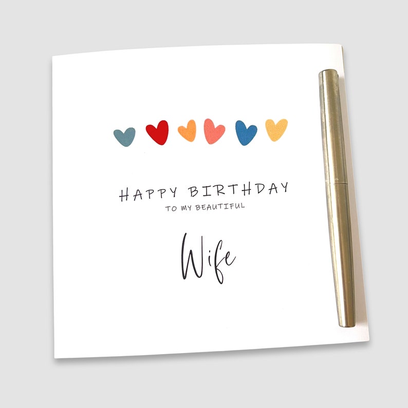 May include: A white card with a row of colorful hearts and the text "Happy Birthday to my beautiful Wife".