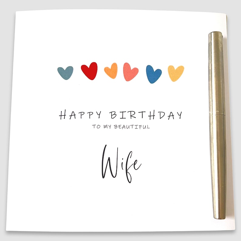 May include: A white card with a colorful row of hearts and the text "Happy Birthday to my beautiful Wife".