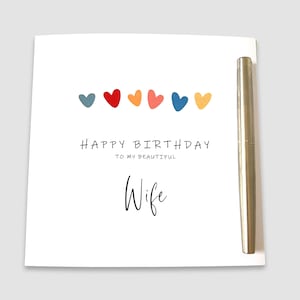 May include: A white card with a colorful row of hearts and the text "Happy Birthday to my beautiful Wife".