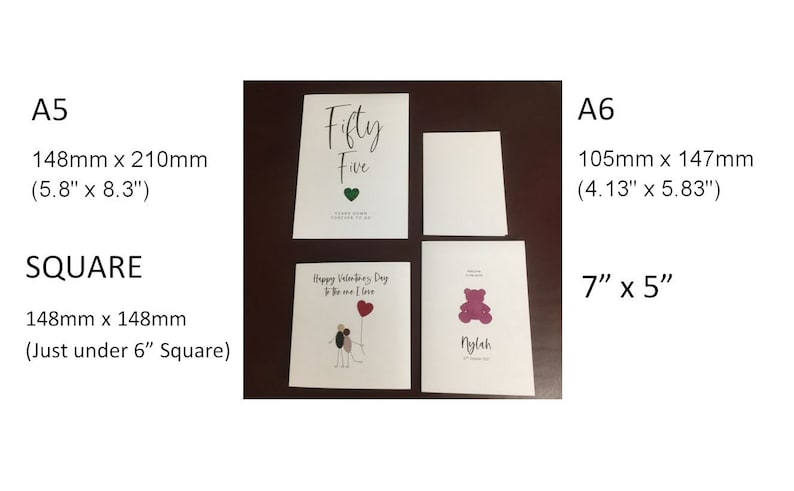 May include: Four blank greeting cards in different sizes, including A5 (5.8" x 8.3"), A6 (4.13" x 5.83"), and square (just under 6" square). The cards are white with a smooth finish. One card has the text "Fifty Five" written in black cursive.