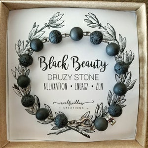 Puede incluir: Pulsera de piedra de lava negra con cierre de plata. La pulsera está en una caja con una tarjeta blanca que dice "Black Beauty Druzy Stone Relaxation Energy Zen wolfwillow creations".