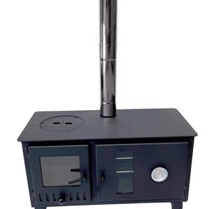 May include: A matte black metal wood-burning stove featuring a tall, cylindrical stainless steel chimney pipe, a glass-paneled firebox door, a secondary compartment door with a built-in circular analogue temperature gauge, and four legs.
