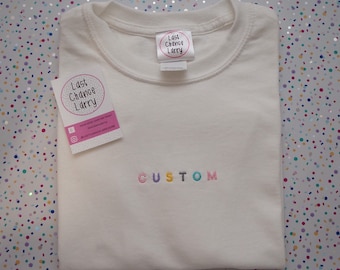 Custom block text embroidered t-shirt. Pastel rainbow font.
