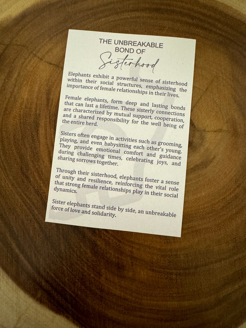 May include: A white card with brown text about the unbreakable bond of sisterhood in elephants. The text describes how female elephants form deep and lasting bonds that are characterized by mutual support, cooperation, and a shared responsibility for the well-being of the entire herd.
