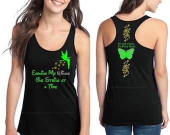 May include: Black tank top with a green fairy graphic and the text "EARNING My WiNGS ONE STRIDE AT A TIME". The back of the tank top has a green butterfly graphic and the text "It's not sweat, It's Pixie Dust!"