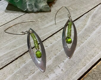 Faceted peridot stones inside stainless steel marquis shape, connected to 925 sterling silver french hook earwires