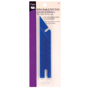 May include: A blue plastic Button Gauge & Point Turner tool by Dritz. The tool has a ruler with inch measurements and is designed for making thread shanks and turning points. The packaging includes text in English and Spanish.