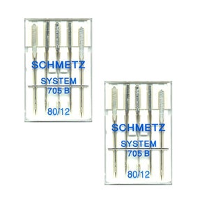Könnte beinhalten: Zwei transparente Kunststoffverpackungen mit Schmetz-Nähmaschinennadeln. Jede Packung enthält fünf silberne Nadeln. Die Packungen tragen den blauen Text "SCHMETZ SYSTEM 705 B 80/12".