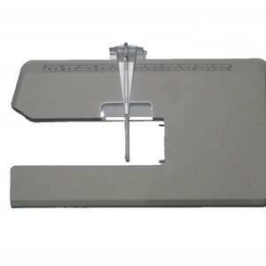 May include: A gray sewing machine extension table with a clear plastic guide. The table has a U-shaped cutout and a ruler printed along the top edge. The clear guide is positioned in the center.