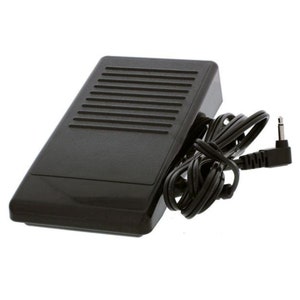 May include: A black sewing machine foot pedal with a ridged top and a black power cable. The cable has a plug at the end. The pedal is rectangular with a slightly angled top.