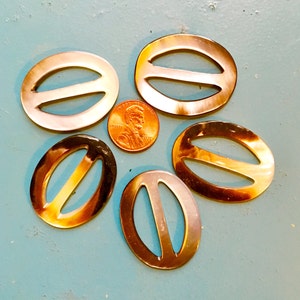 May include: A set of three ceramic nesting bowls with a speckled, cream-colored glaze. The bowls vary in size, with the largest measuring approximately 6 inches in diameter. Each bowl has a rounded shape and a simple, minimalist design.