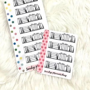 May include: Two sheets of planner stickers featuring black and white illustrations of bookshelves with books. The stickers are on a white fuzzy surface. The text "Sandys Planner Shop" is on the bottom of the stickers.