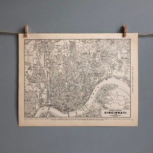 Puede incluir: Un mapa vintage de Cincinnati, Ohio, impreso en blanco y negro. El mapa muestra las calles, los ríos y los puntos de referencia de la ciudad. El título "Central Section Cincinnati" está impreso en la parte inferior del mapa.