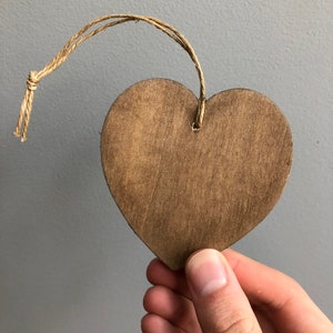 May include: A brown wooden heart-shaped ornament with a twine string attached.