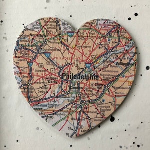 May include: A heart-shaped map of Philadelphia, Pennsylvania, with major roads and highways highlighted. The map is made of wood and has a distressed, vintage look.