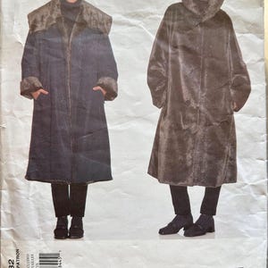 Puede incluir: Un patrón de costura original de Issey Miyake Vogue vintage. El patrón presenta dos abrigos largos con cuellos y puños grandes. Los abrigos se muestran en azul oscuro y marrón, con cierres de botones y bolsillos. El número de patrón es 2182.