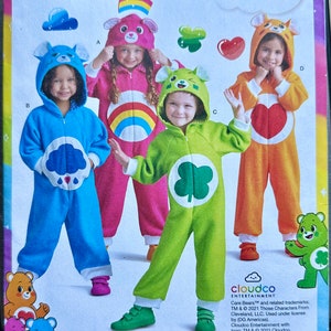 May include: Simplicity sewing pattern featuring Care Bears costumes. The pattern includes instructions for making four different Care Bear-themed jumpsuits in various colors: blue, pink, green, and orange. The costumes have attached hoods with bear ears.