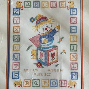 Kit de punto de cruz estampado vintage de los años 80 de Columbia Minerva, modelo Jack In The Box Birth Sampler.
