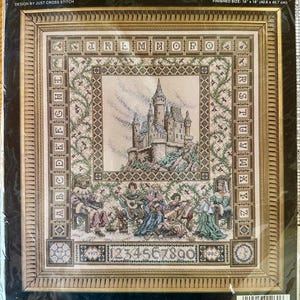 May include: A Janlynn counted cross stitch kit, featuring "The Castle Sampler." The finished size is 16" x 18". The design includes a castle, figures, and alphabet letters. The kit contains fabric, floss, a needle, and instructions. The kit is in a gold frame.